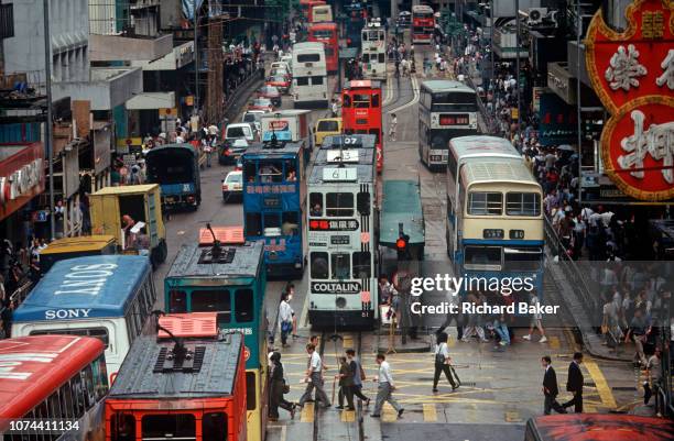 While still a British colony, heavy 1990s traffic of cars, trams and buses, on 21st April 1995, in Central, Hong Kong, China.