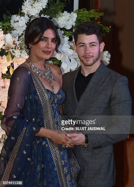 Indian Bollywood actress Priyanka Chopra and US musician Nick Jonas, who were recently married, pose for a picture during a reception in Mumbai,...