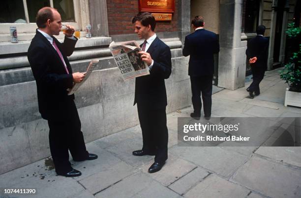Businessman reads a 1992 edition of the Daily Express whose headline announces that Prime Minister John Major is fighting the Pound Crisis, on a...