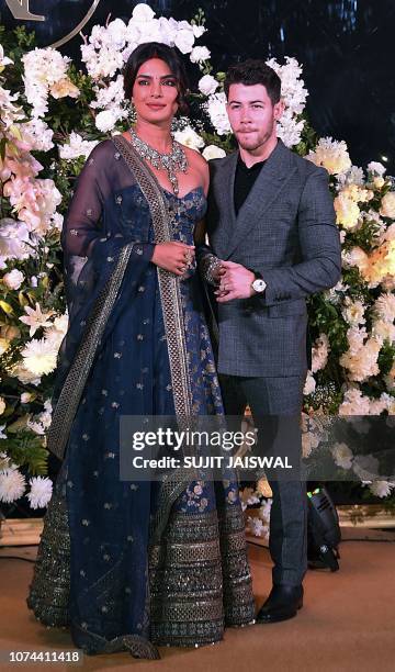 Indian Bollywood actress Priyanka Chopra and US musician Nick Jonas, who were recently married, pose for a picture during a reception in Mumbai,...