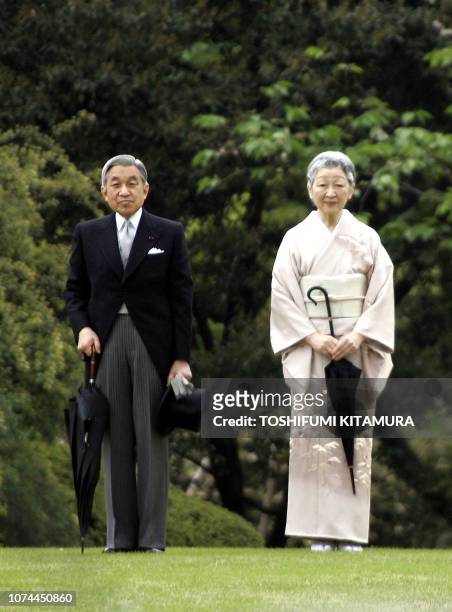 Japanese Emperor Akihito and Empress Michiko listen to the national anthem at the start of the annual spring garden party at the Akasak Imperial...