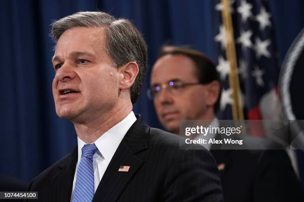 Director Christopher Wray speaks as U.S. Deputy Attorney General Rod Rosenstein listens during a news conference to announce a China-related national...
