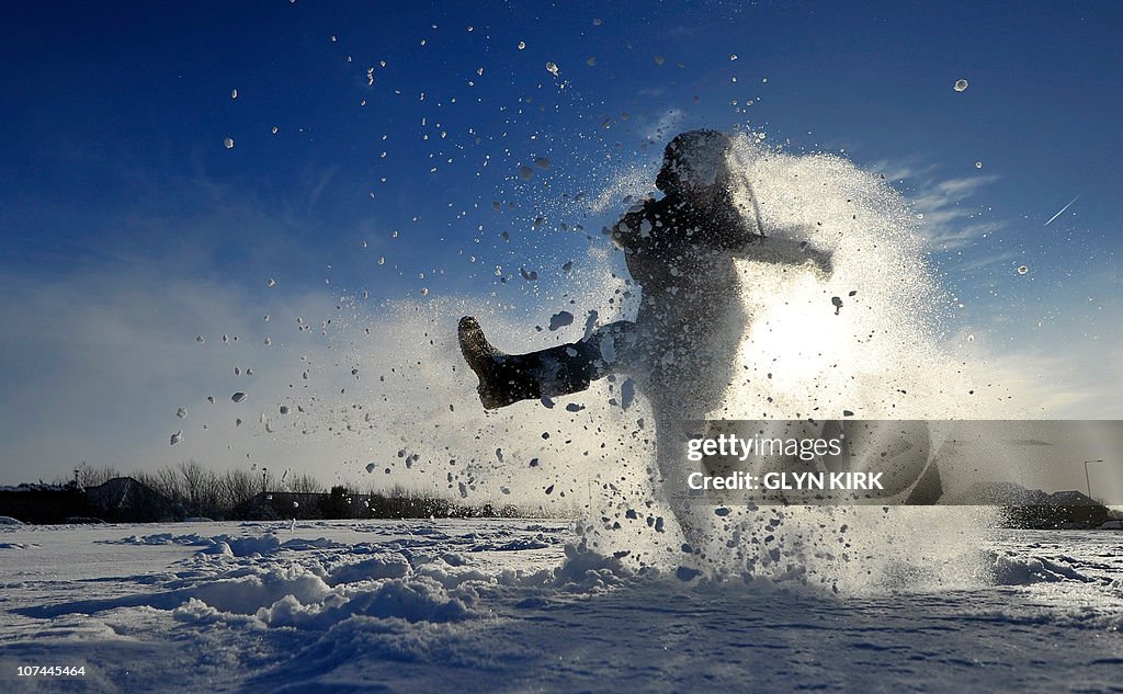 Archie Kirk plays in the snow as his sch
