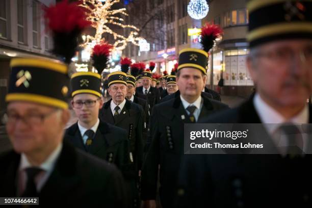 Miners from the Prosper-Haniel coal mine walk after a the religious service at the Dom cathedral through the city on December 20, 2018 in Essen,...