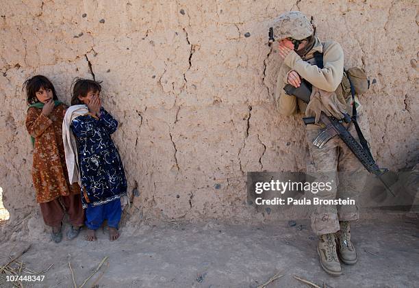 Corporal Catherine Broussard a US Marine with the FET 1st Battalion 8th Marines, Regimental Combat team II tries to communicate with some Afghan...