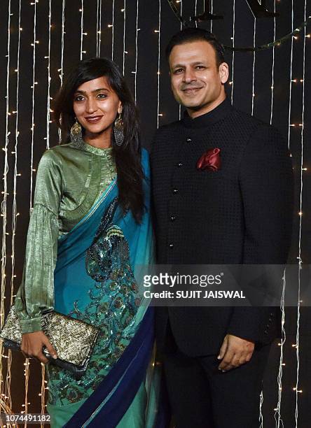 Indian Bollywood actor Vivek Oberoi with his wife Priyanka Alva pose for a picture during the wedding reception party of actress Priyanka Chopra and...