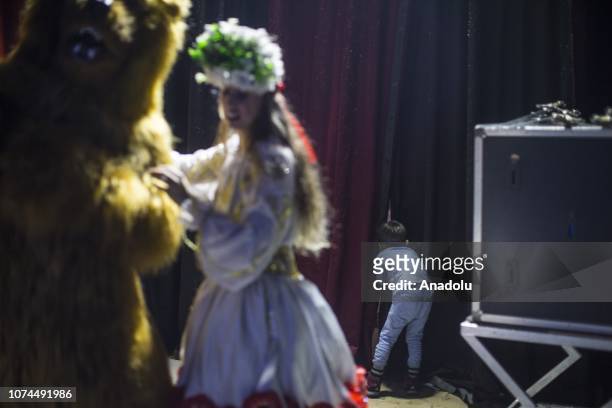 Son of Ulas and Melike Cankurt peeks through a curtain in the backstage of an animal-free circus in Ankara, Turkey on December 15, 2018. Owners of an...