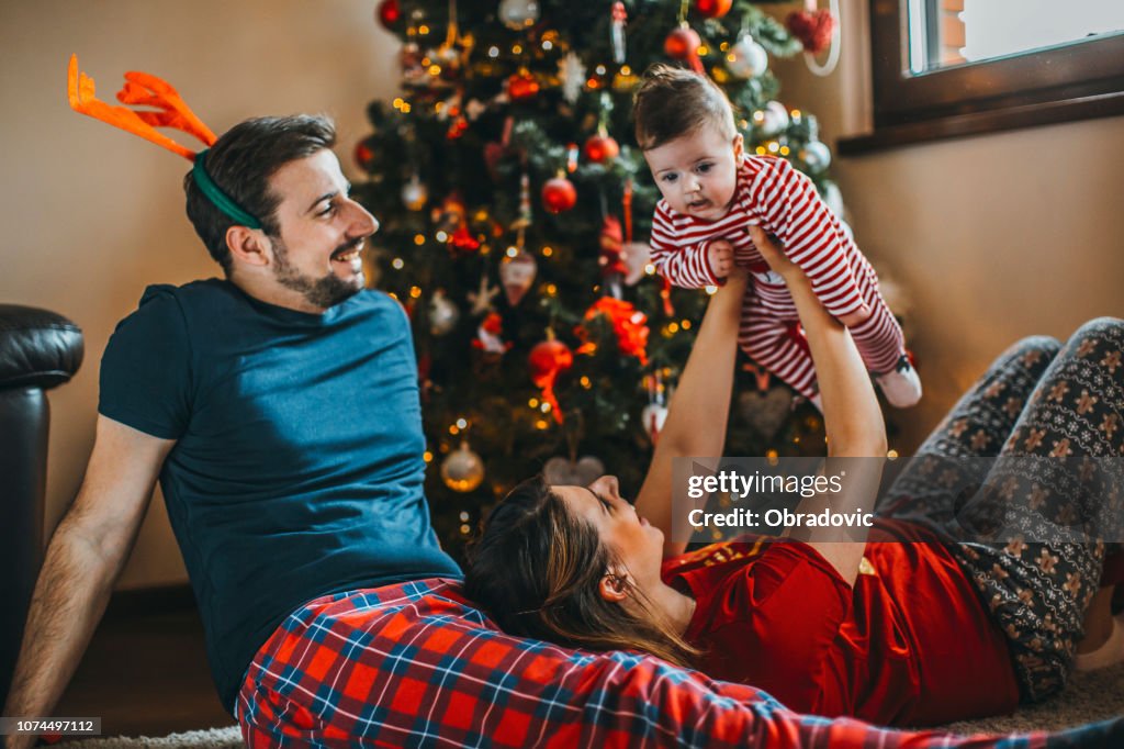 Buon Natale! felice famiglia madre padre e figlio con regali vicino albero