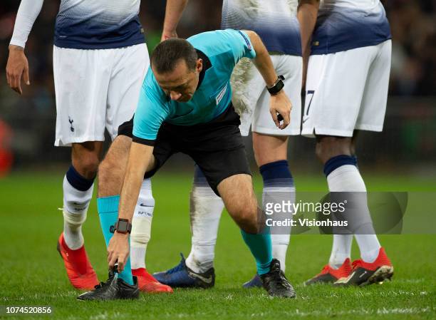 Referee Cuneyt Cakir marks the defensive wall position with aerosol spray during the Group B match of the UEFA Champions League between Tottenham...