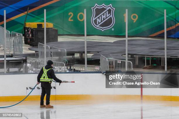 Members of the NHL ice crew spray water as they build the ice rink at Notre Dame Stadium on December 21, 2018 in South Bend, Indiana in preparation...