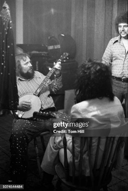 Country guitarist and fiddler Charlie Daniels warms-up backstage with Al Kooper and WQXI-Radio personality J.J. Jackson before performing at...