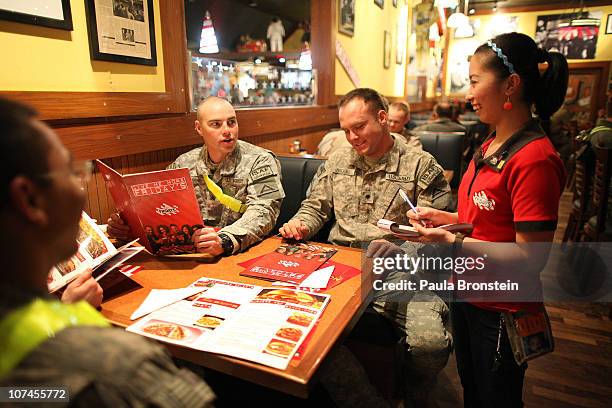 Waitress Erica Dinglasan takes a dinner order from U.S Army Sargent Jackie Rogers and Specialist Charles Brooks at the T.G.I Friday's restaurant at...
