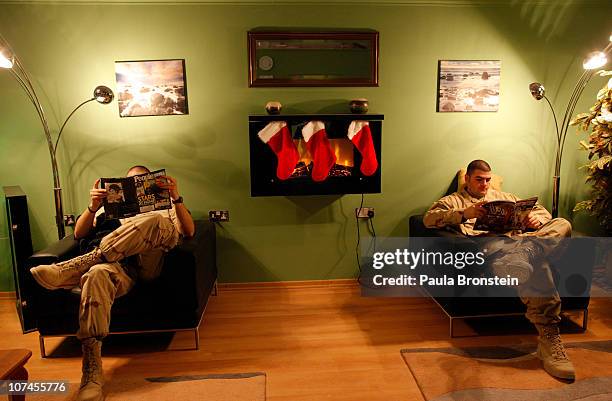 Military get some quiet time reading while waiting for computers at the United Service members Organization lounge at Kandahar Air Field December 9,...