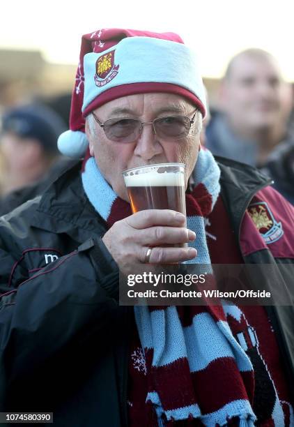 Fan in a West Ham Christmas hat takes a sip of his pint of beer ahead of the Premier League match between West Ham United and Watford FC at London...