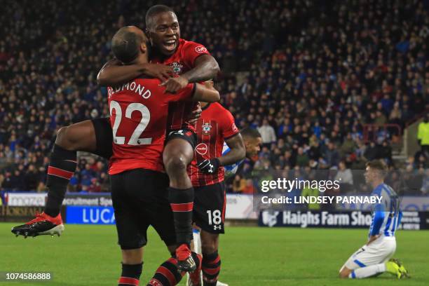 Southampton's Irish-born striker Michael Obafemi jumps into the arms of Southampton's English midfielder Nathan Redmond as he celebrates after...