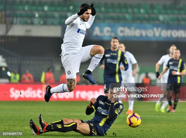 Inter Milan's Argentine forward Mauro Icardi jumps over Chievo's Italian midfielder Fabio Depaoli during the Italian Serie A Football match Chievo...