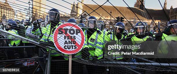 Police officers come under attack as student protesters throw a fence in Parliament Square on December 9, 2010 in London, England. Parliament is...