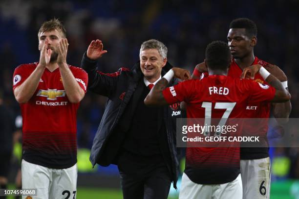 Manchester United's Norwegian caretaker manager Ole Gunnar Solskjaer celebrates with his players on the pitch after the English Premier League...