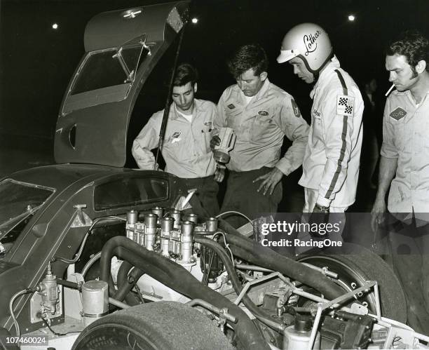 Driver Lothar Motschenbacher and his crew look over the engine of their Ford GT-40 racer during a Sports Car event in the mid-1960s.