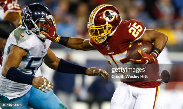 Chris Thompson of the Washington Redskins stiff arms Wesley Woodyard of the Tennessee Titans while running with the ball during the third quarter at...