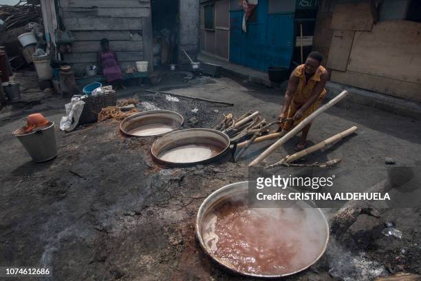 Emilia, a pito maker, watches pito's boiling in Tema, Accra, on December 12, 2018. Emilia's family has been making and serving pito in Tema for 35...