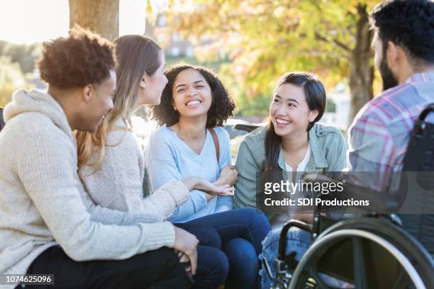 group of college friends talk in circle outdoors - person of colour stock pictures, royalty-free photos & images