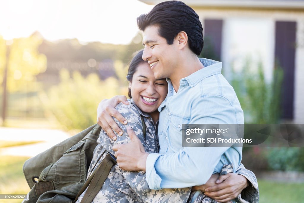 Female in uniform shares a hug with her husband