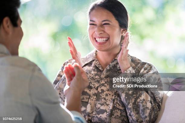 young female in uniform can't contain excitement as her boyfriend proposes - homecoming stock pictures, royalty-free photos & images