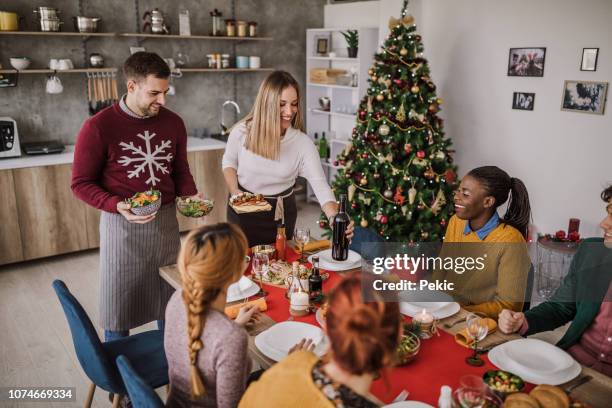 having christmas dinner with friends - christmas guest stock pictures, royalty-free photos & images