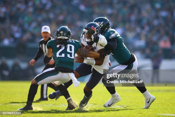 Quarterback Deshaun Watson of the Houston Texans is sacked by free safety Avonte Maddox and defensive end Daeshon Hall of the Philadelphia Eagles in...