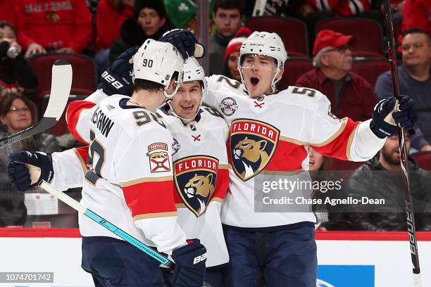 Jared McCann, Denis Malgin and MacKenzie Weegar of the Florida Panthers celebrate after Malgin scored against the Chicago Blackhawks in the third...