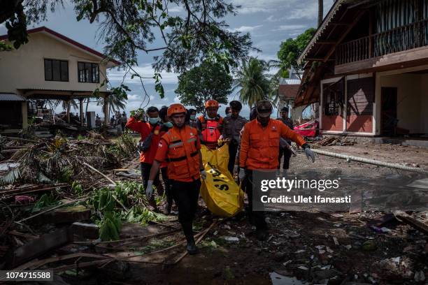 Rescue workers recover the body of a victim of the tsunami during a search at a resort hotel on December 24, 2018 in Carita, Banten province,...