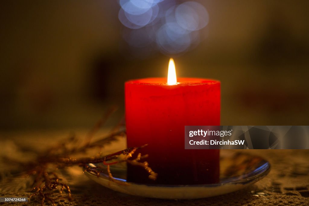 Lit candle, Christmas ornaments.