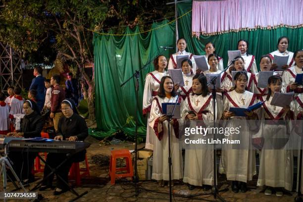Pilgrims and locals take part in the procession of Baby Jesus led by Bishop Joseph Nguyen Nang during the Christmas Midnight Mass on the site of Phat...