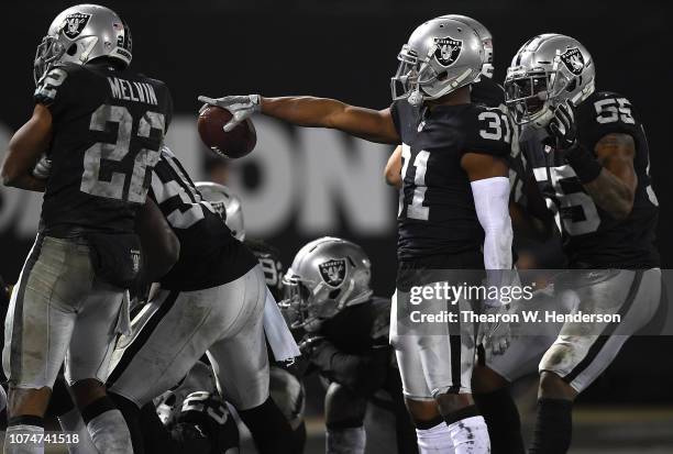 Marcus Gilchrist of the Oakland Raiders and teammates celebrate after Gilchrist intercepted a pass against the Denver Broncos late in the fourth...