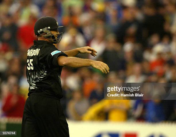 Mark Richardson of New Zealand fields at third man wearing a helmet after the crowd threw objects on the ground, during the VB Series One Day...