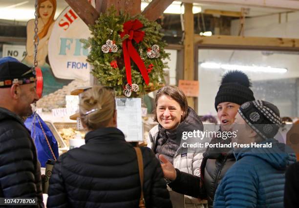 Cordie Southall, center, of Freeport and Margaret Donahue of Yarmouth catch up with friends while shopping early Sunday morning at Harbor Fish...