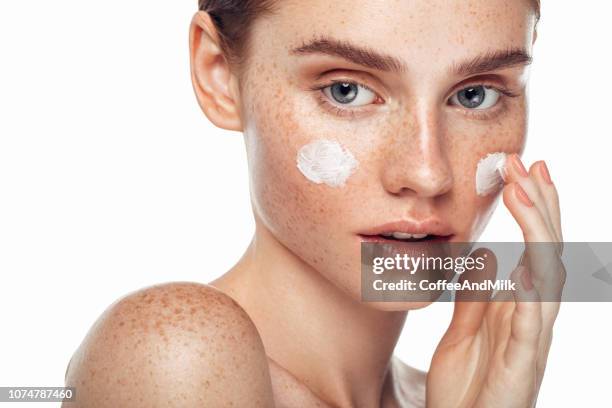 ragazza che infligge crema - caratteristica della pelle foto e immagini stock