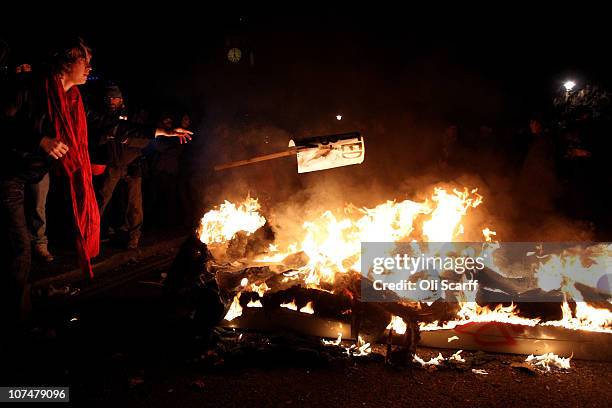 Student protestor burns a plackard in a fire in Parliament Square on December 9, 2010 in London, England. Parliament is voting today on whether to...