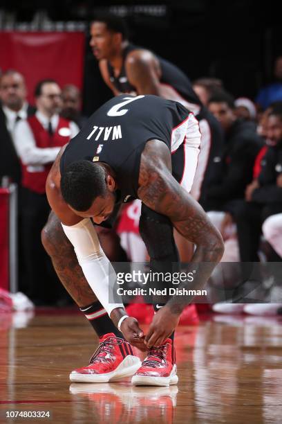 John Wall of the Washington Wizards ties his sneakers during the game against the Houston Rockets on December 19, 2018 at the Toyota Center in...