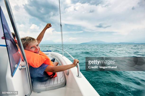 little boy enjoying boat ride on lake garda - kid sailing imagens e fotografias de stock