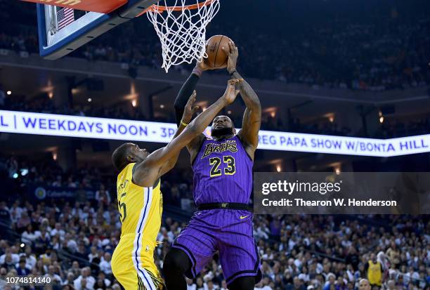 LeBron James of the Los Angeles Lakers goes up to shoot and get fouled by Kevin Durant of the Golden State Warriors during the first half of their...