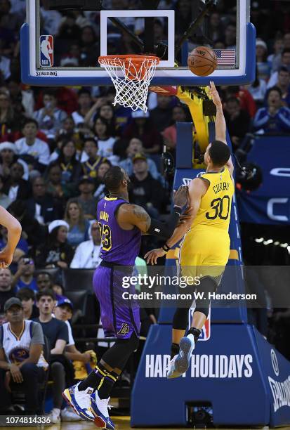 Stephen Curry of the Golden State Warriors shoots over LeBron James of the Los Angeles Lakers during the first half of their NBA Basketball game at...