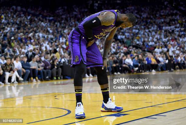 LeBron James of the Los Angeles Lakers leans over in pain after he was hurt against the Golden State Warriors during the second half of their NBA...