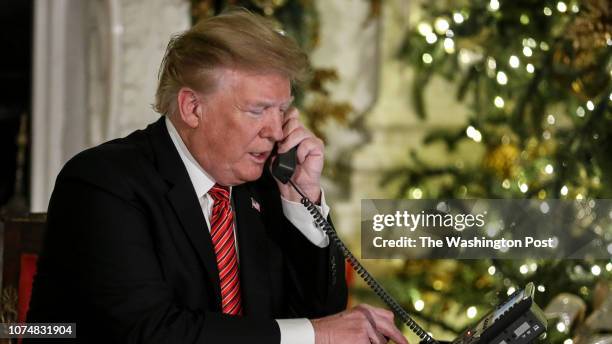 President Donald Trump and first lady Melania Trump speak on the phone with children as they track Santa Claus with the North American Aerospace...