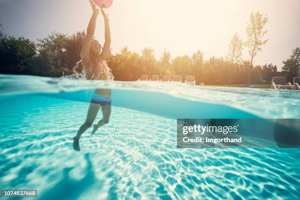 kleiner junge ballspielen im schwimmbad - jump in pool stock-fotos und bilder