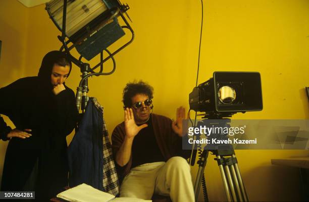 Dariush Mehrjui, renowned Iranian director, during a break while directing 'The Pear Tree', on location in Tehran, 1st February 1999. A veiled female...