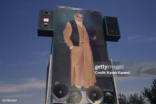 Picture of Ayatollah Khomeini surrounded by loudspeakers goes on wheels, playing his speeches, during his funeral at Behesht Zahra cemetery, Tehran,...