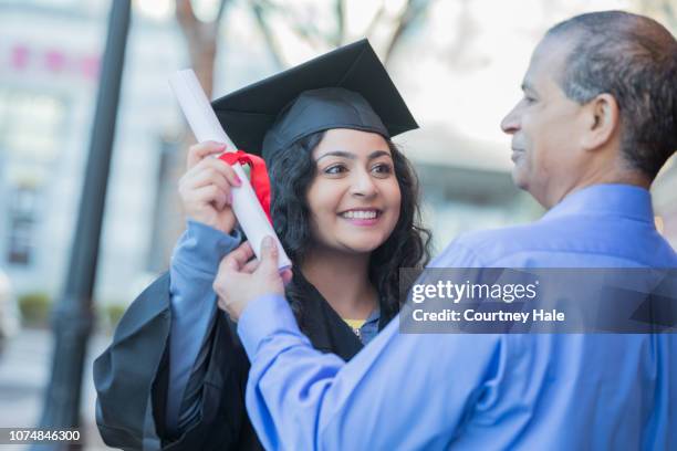 young woman showing off diploma to her dad at graduation - degree stock pictures, royalty-free photos & images