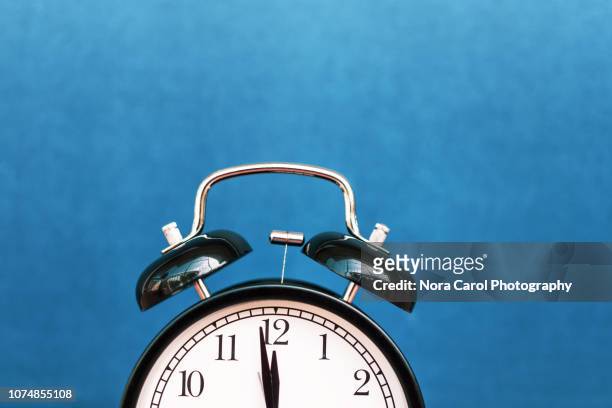 alarm clock pointing at 12 midnight - clock face fotografías e imágenes de stock